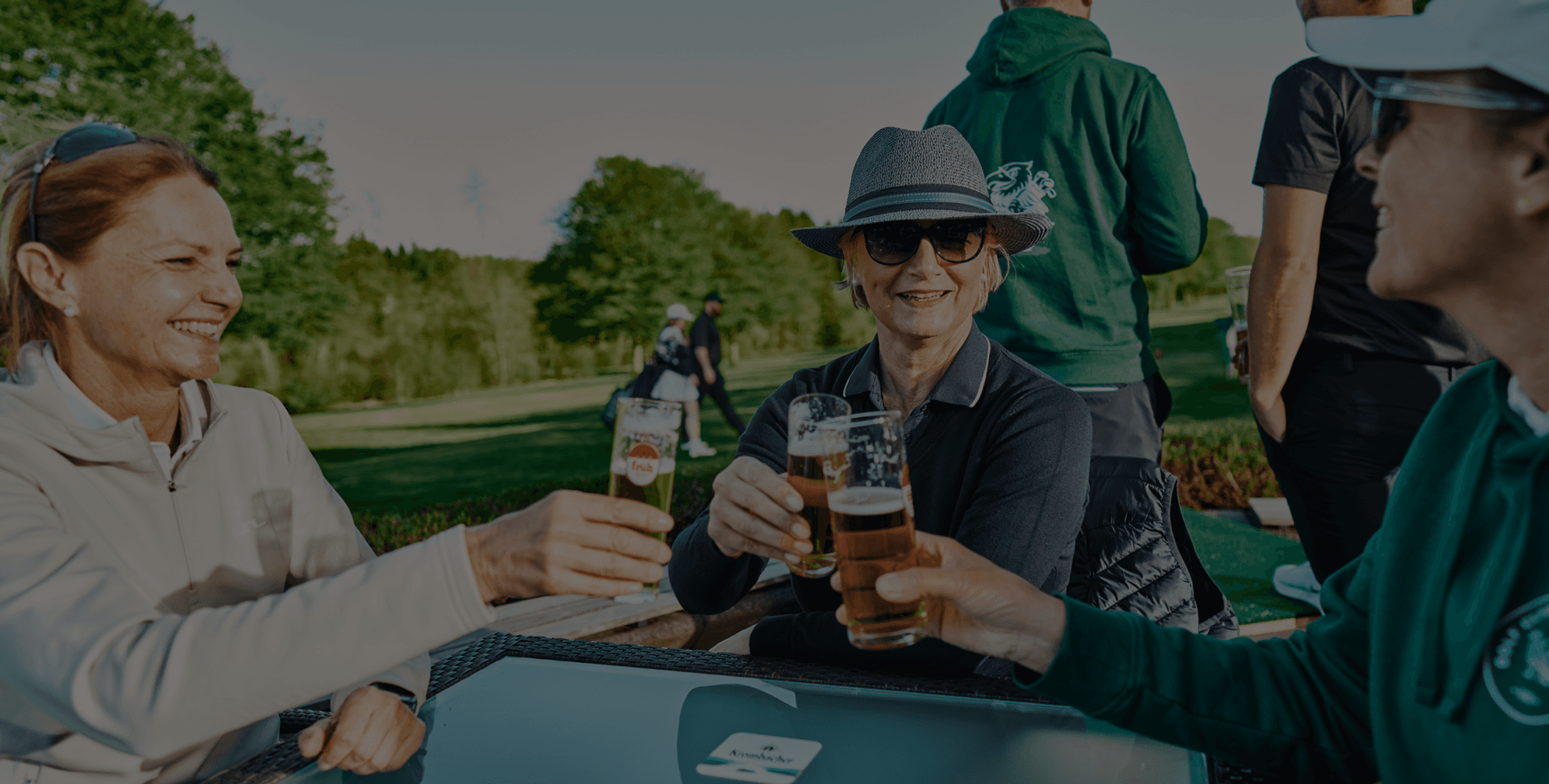 Freunde stoßen bei Sonnenschein im Golfclub an