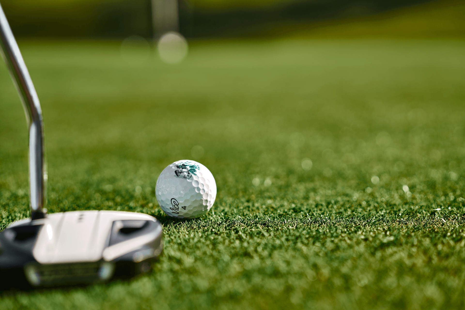 Golfschläger und Ball auf gepflegtem Grün, bereit für den Schlag