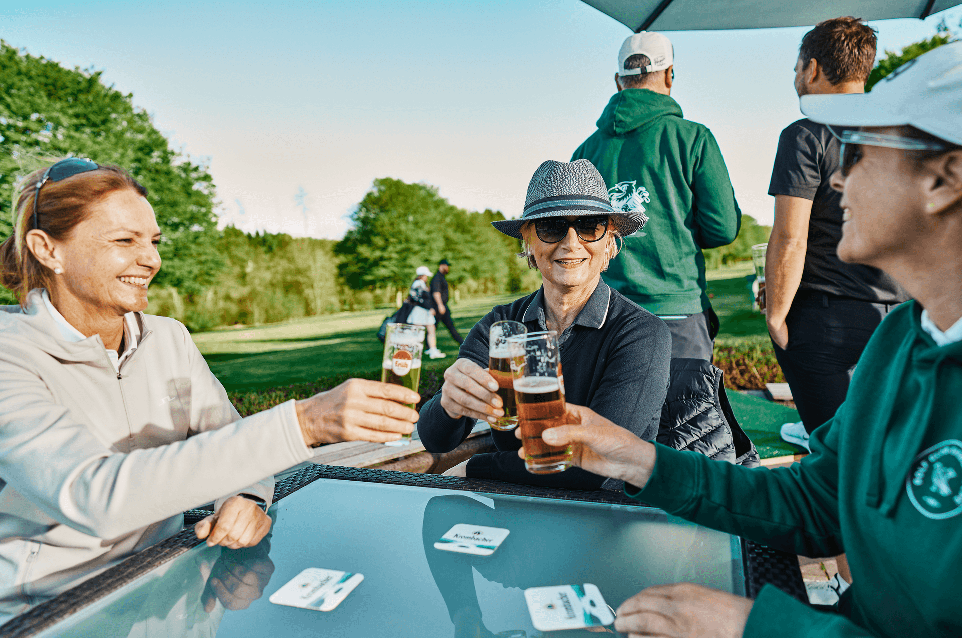 Gesellige Golfer genießen ein Getränk im Freien