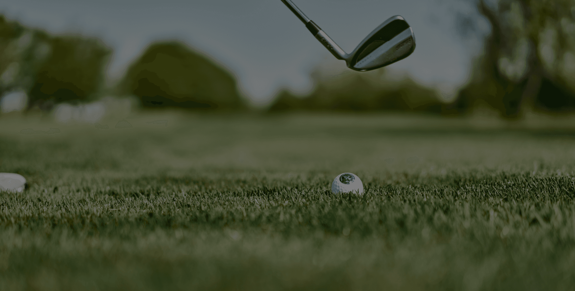 Golfschläger nah am Golfball auf saftigem Grün des Golfplatzes