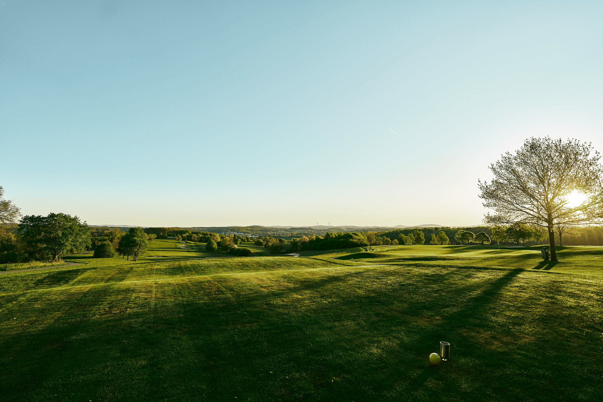 Weitläufiger Golfplatz im Sonnenuntergang mit Blick auf die Landschaft