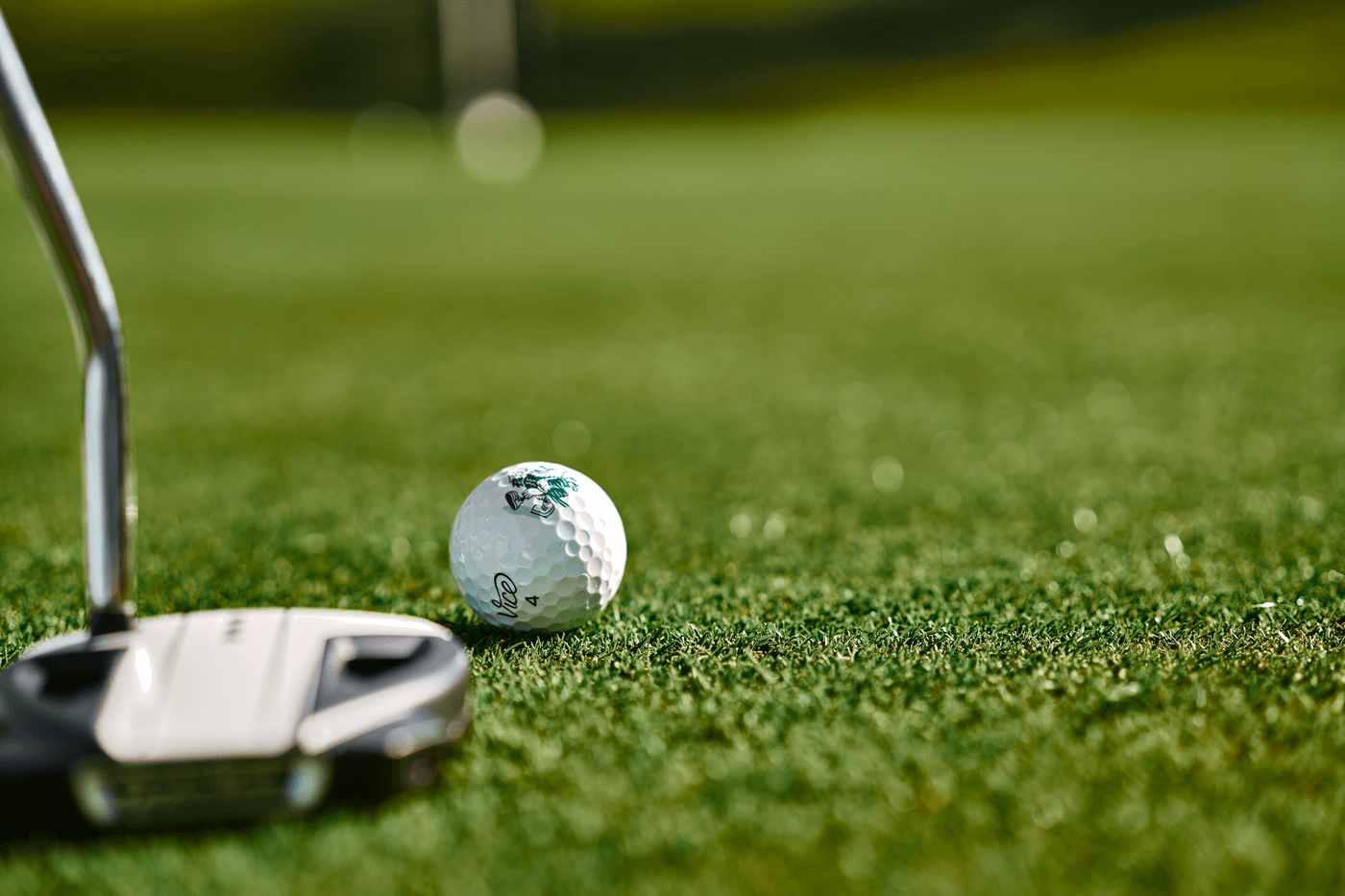 Golfschläger und Ball auf gepflegtem Grün, bereit für den Schlag